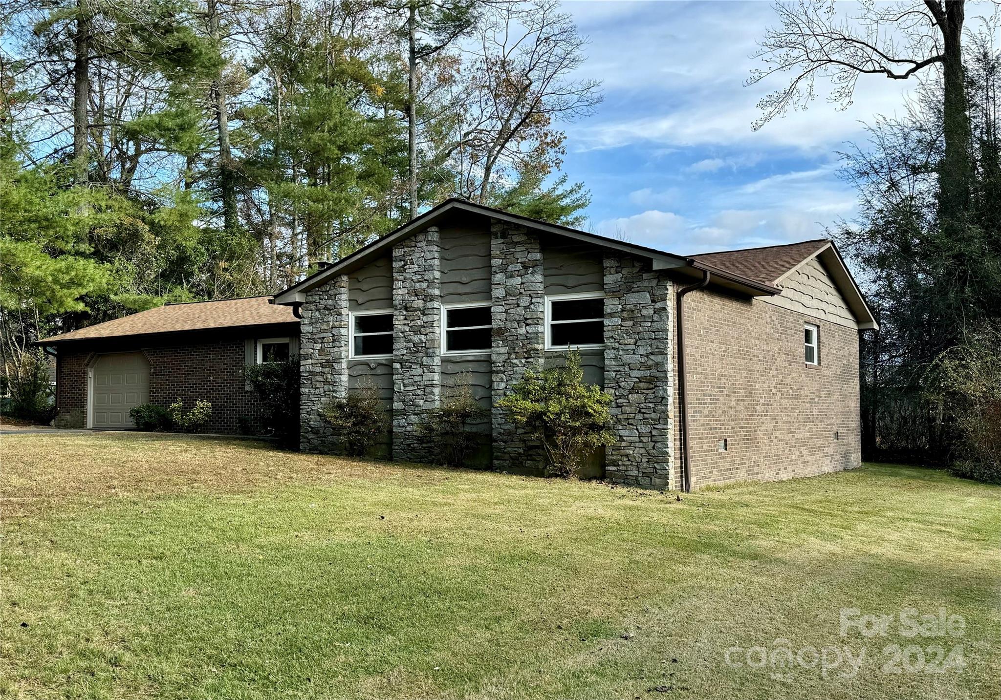 a front view of house with yard and trees around