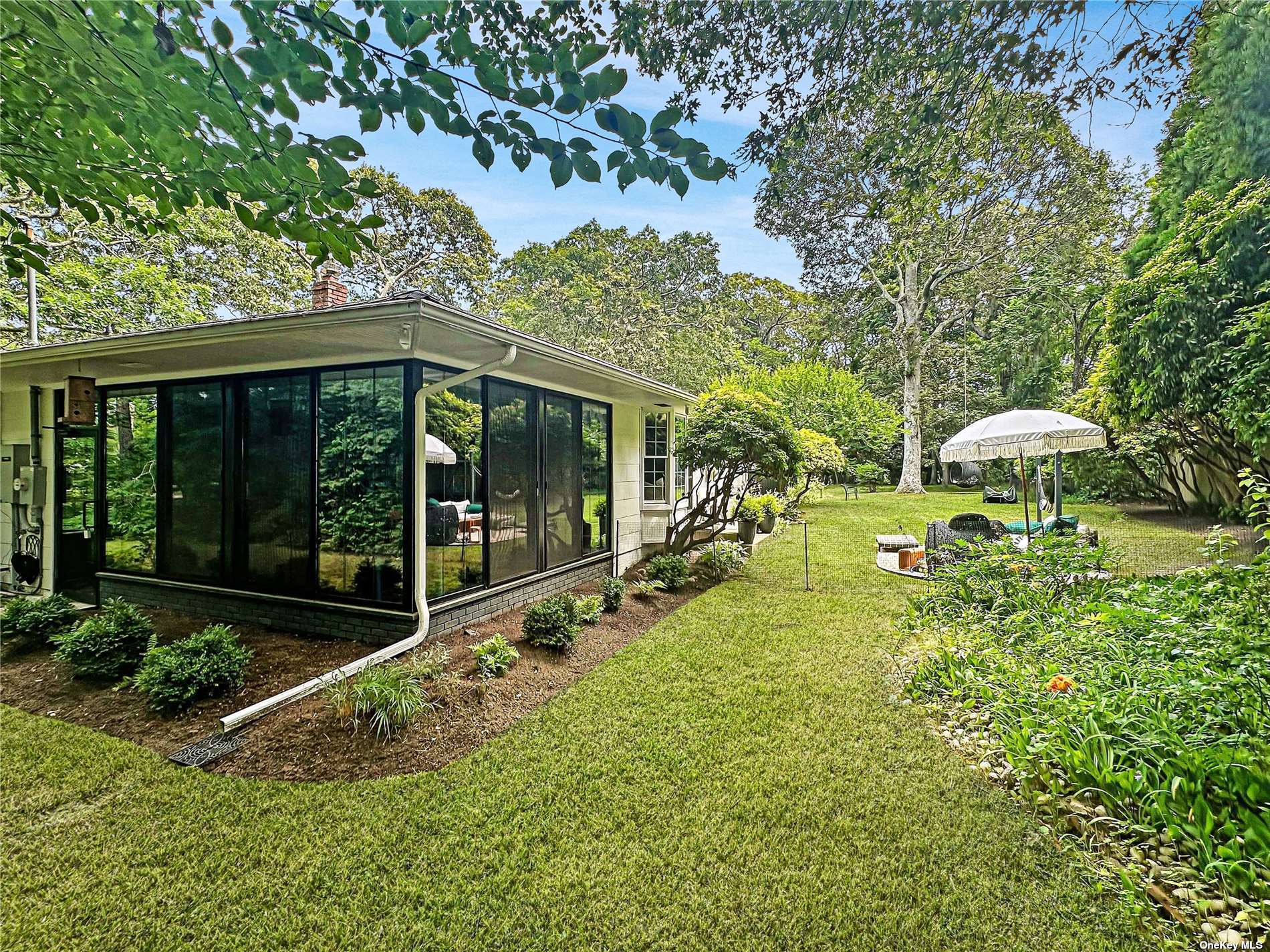 a view of a house with backyard and sitting area