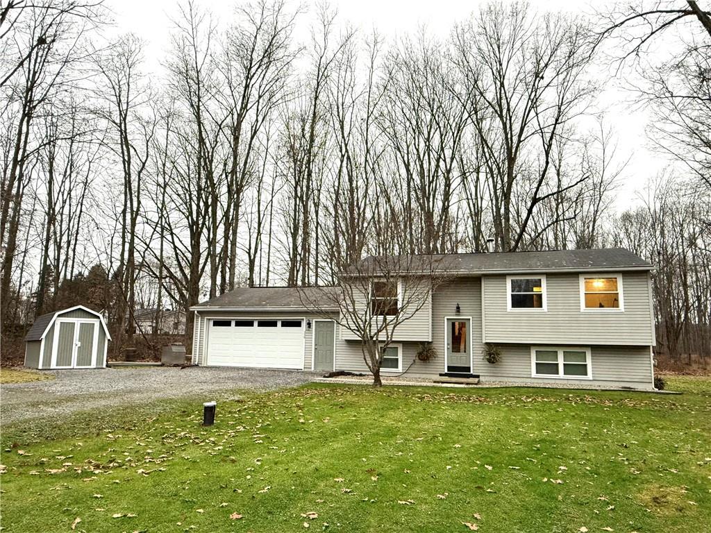 a front view of a house with a garden and tree