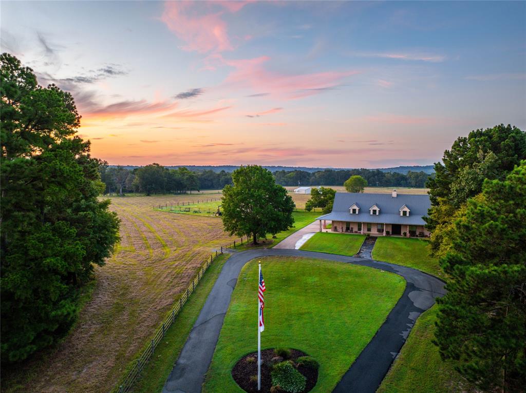 an aerial view of a house with a garden and lake view