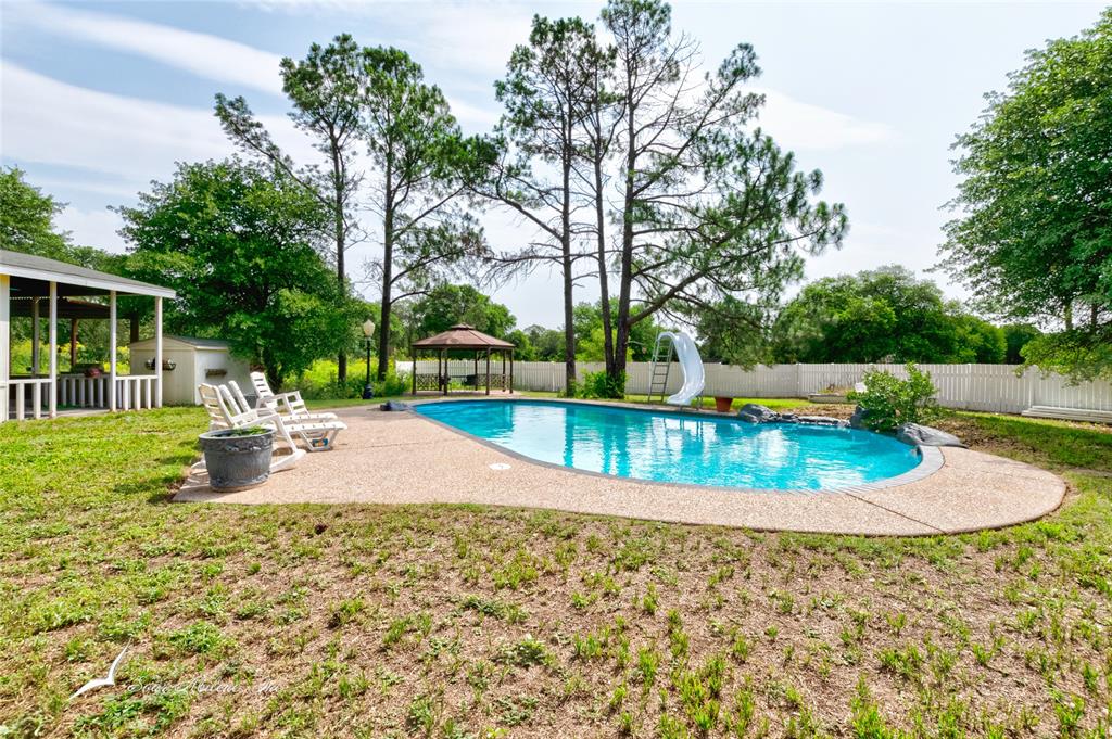 a view of a backyard with swimming pool