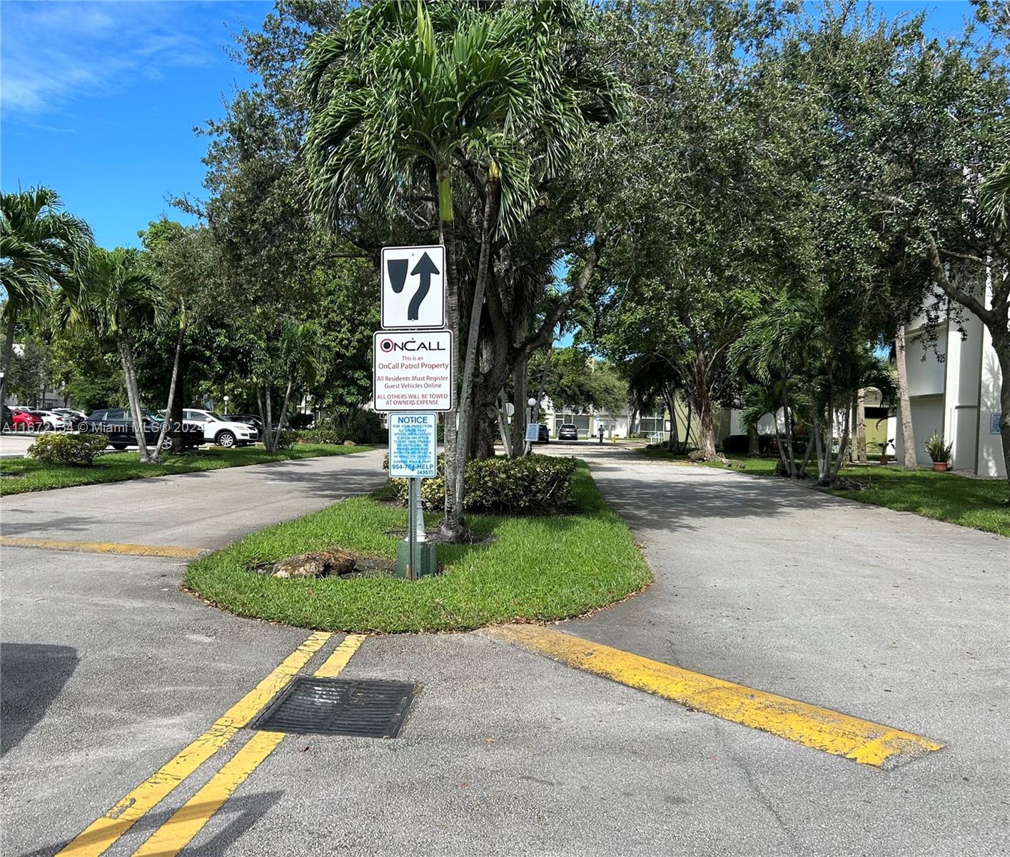 a sign board with yard and trees