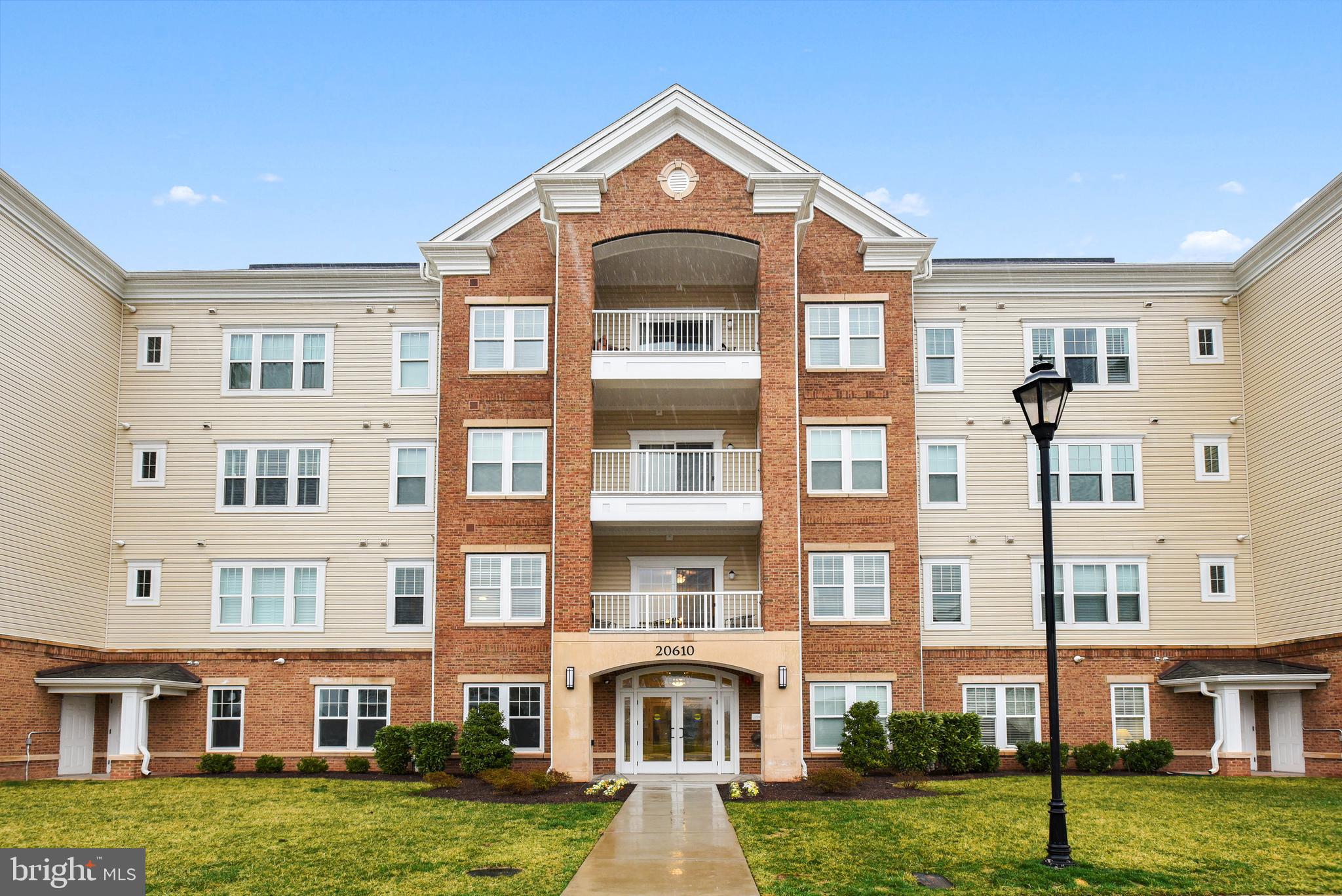 a front view of a residential apartment building with a yard