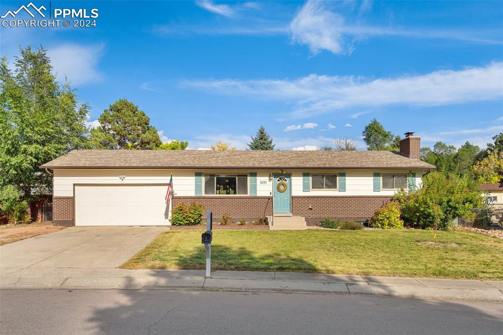 Single story home featuring a front yard and a garage