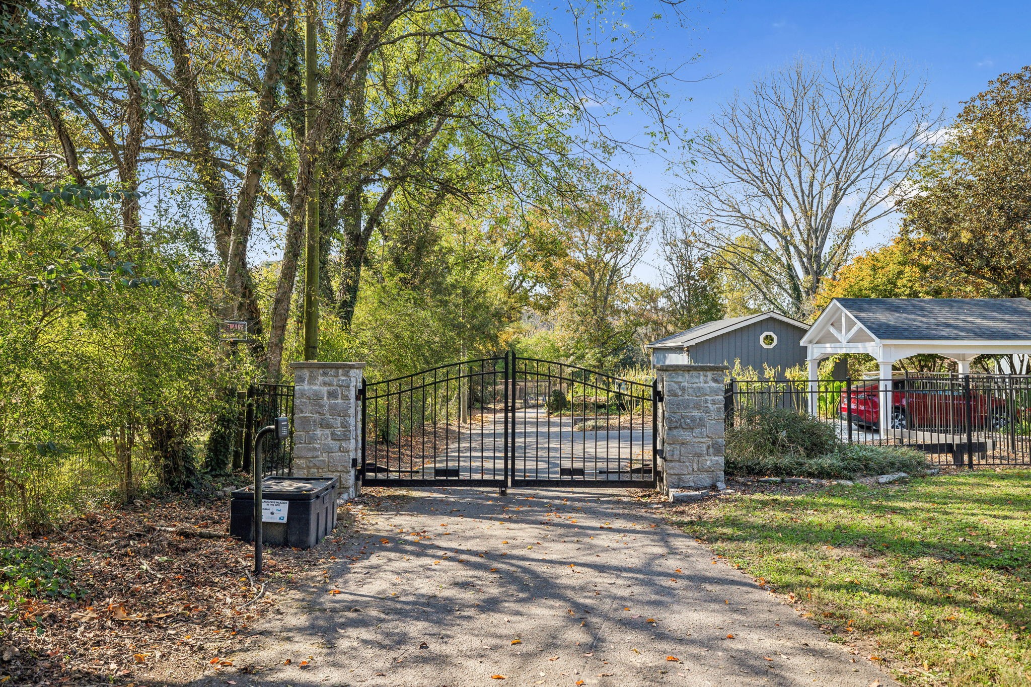 Hidden down the driveway is the security gate w/ stone columns, keypad, & remote access.  The driveway is private so the property is not visible from S. Harpeth Ct. The entire property is fenced w/ lush landscaping along most of the property lines.