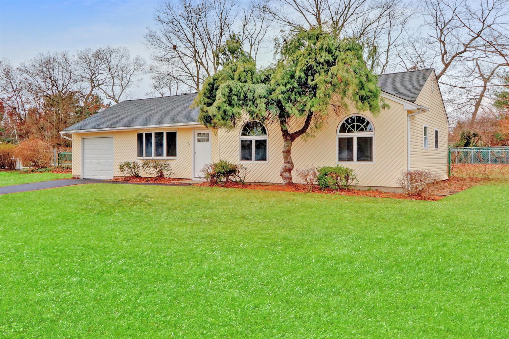 View of front of property featuring a garage and a front yard