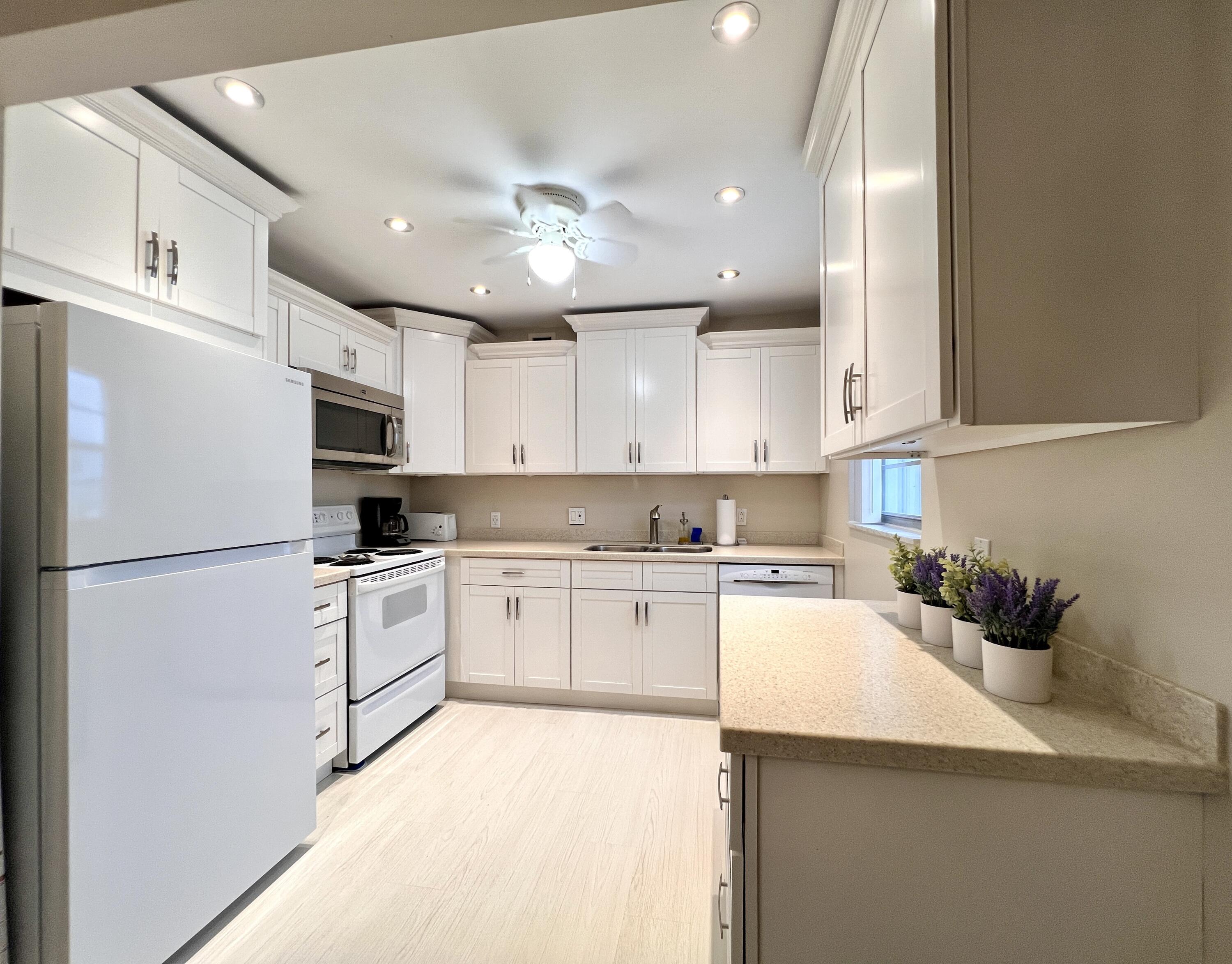 a kitchen with refrigerator a sink and white cabinets