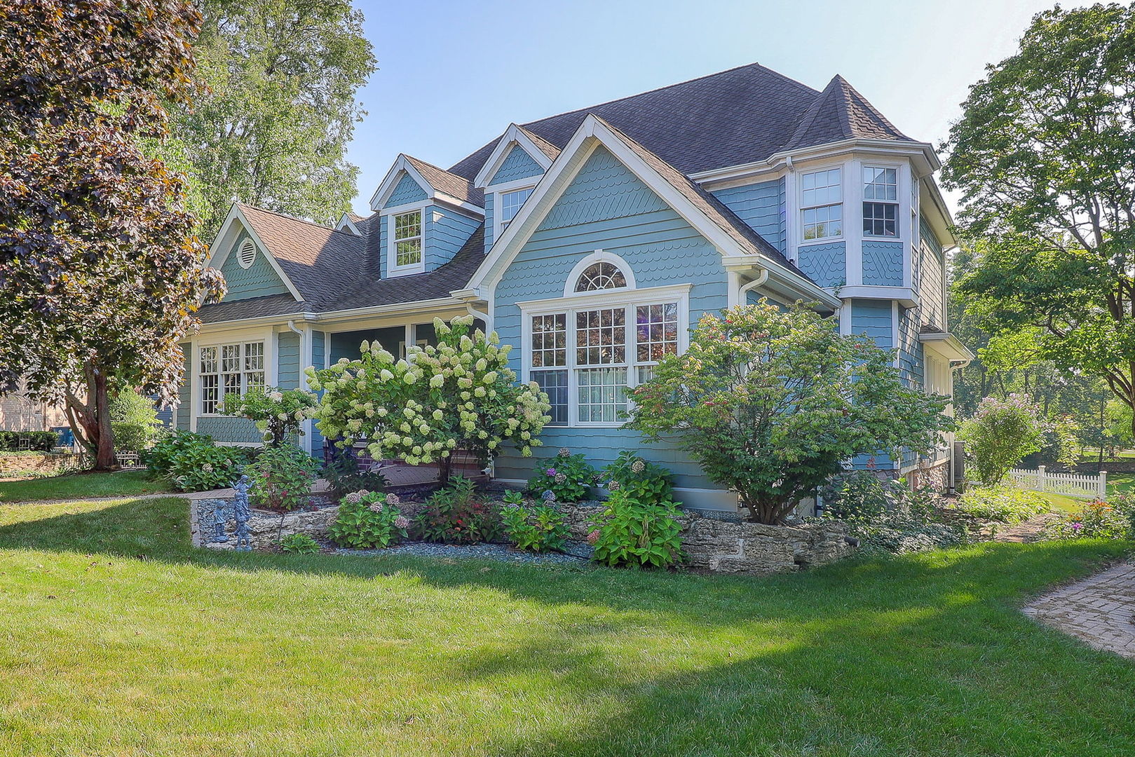 a front view of a house with a yard and trees