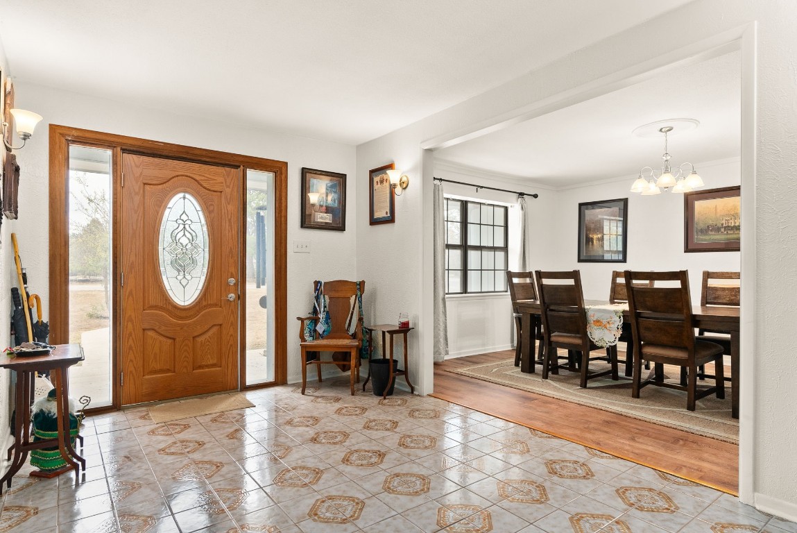 a living room with furniture a dining table and large window with wooden floor