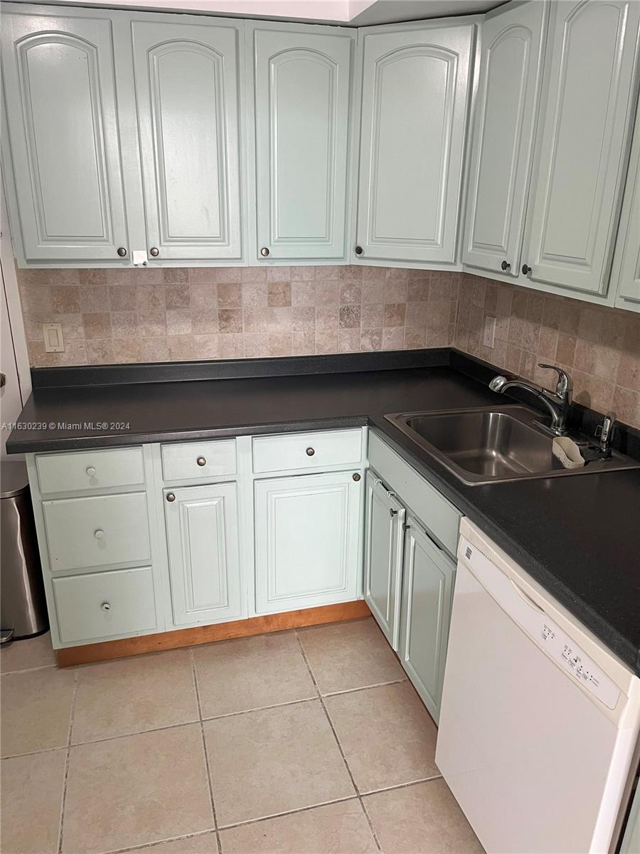 a kitchen with granite countertop white cabinets and sink