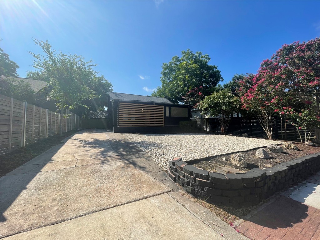 a view of a backyard with table and chairs and wooden fence