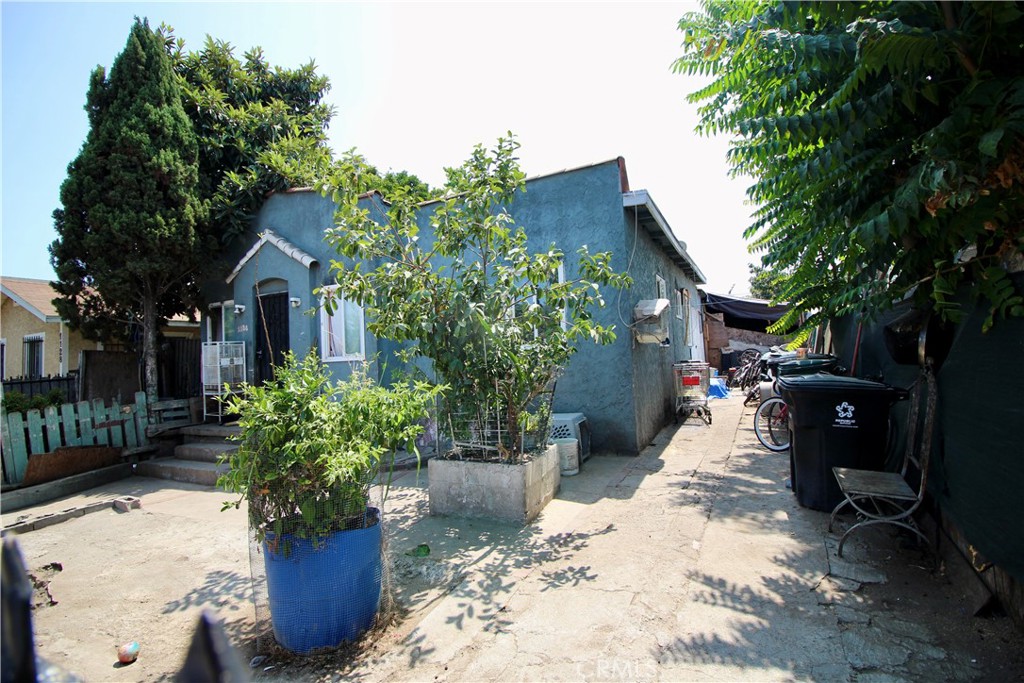 a front view of a house with a yard and potted plants