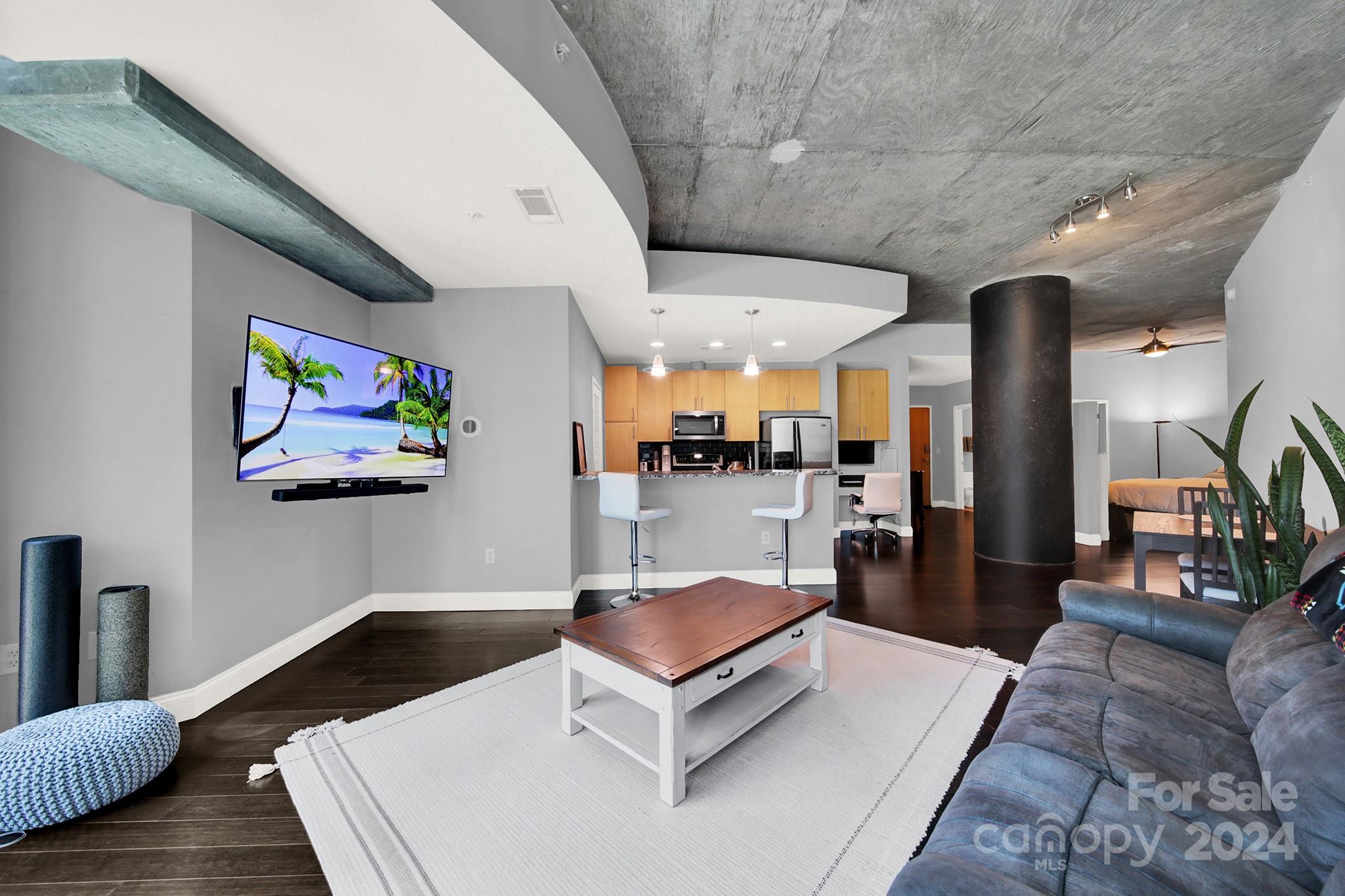 a living room with stainless steel appliances kitchen island granite countertop furniture and a view of kitchen