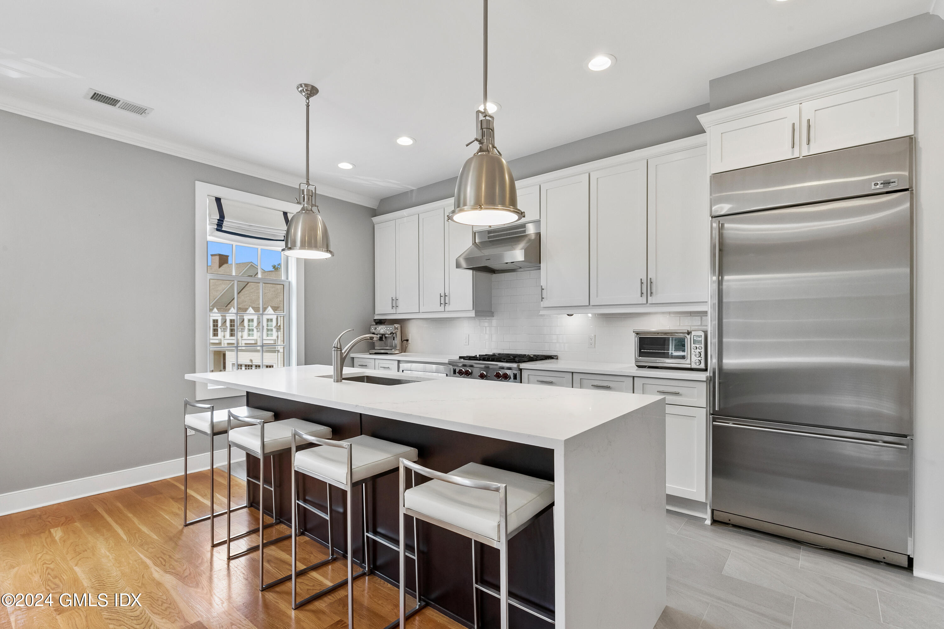 a kitchen with kitchen island a stove a chandelier and a refrigerator