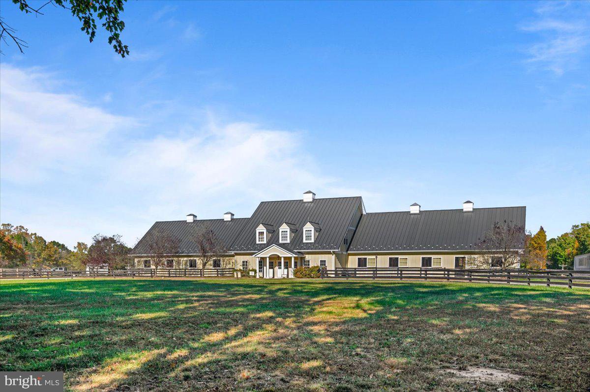 a view of a big house with a big yard and large trees