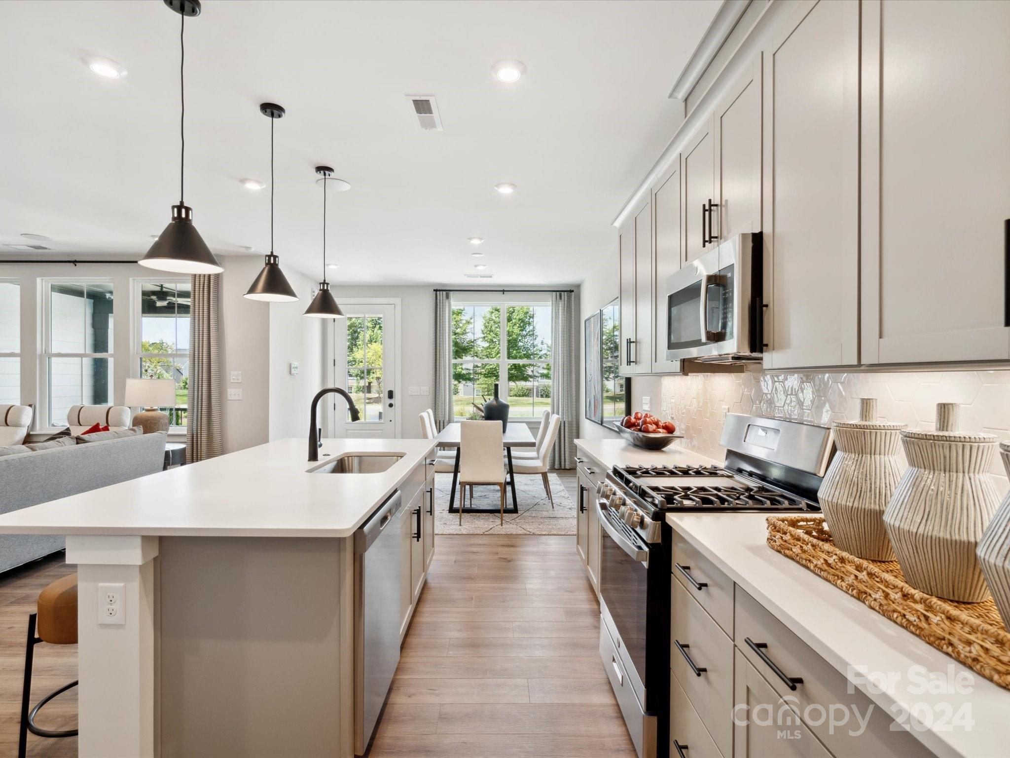 a kitchen with stainless steel appliances a sink a stove and a wooden floors