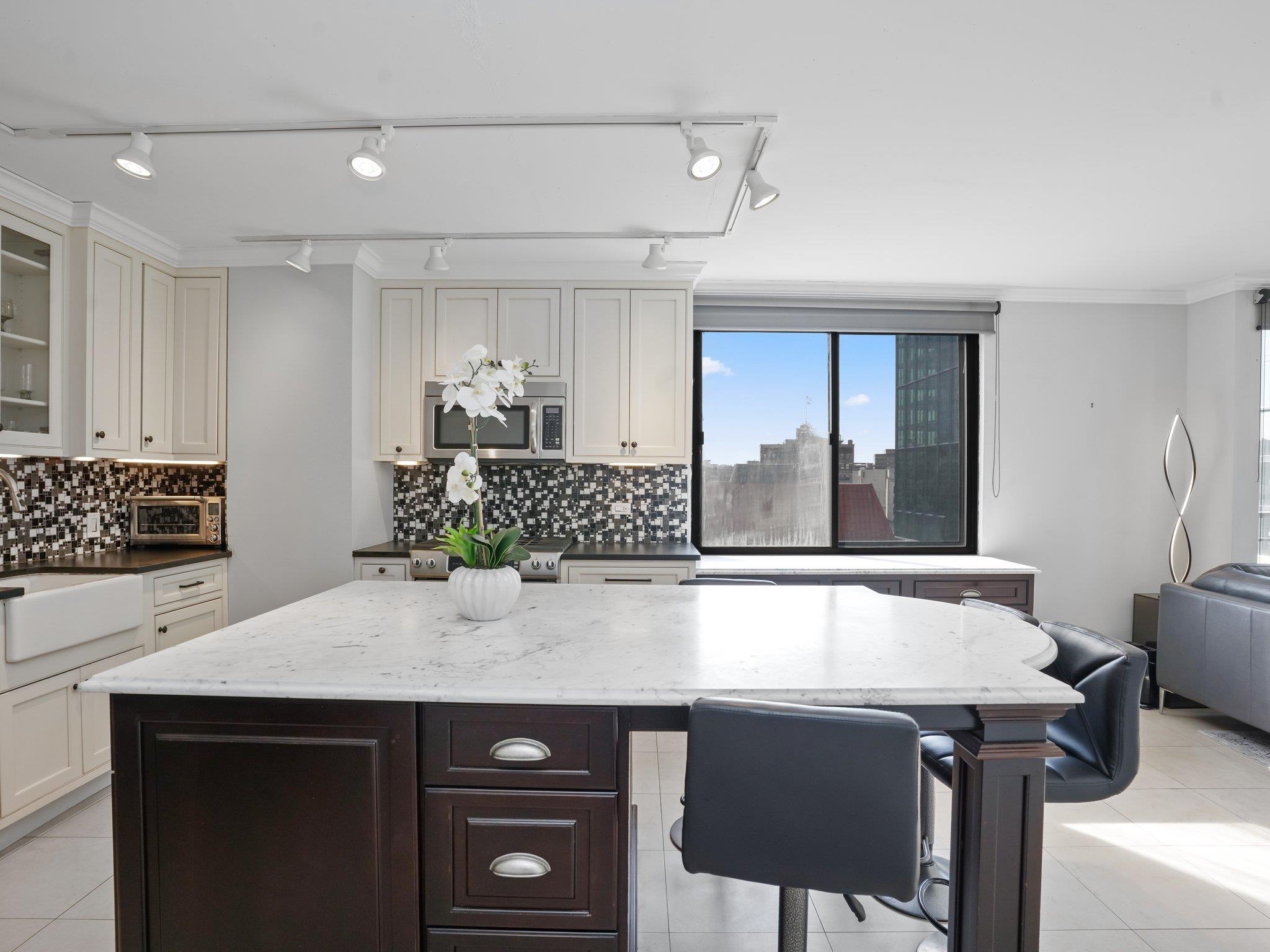 a view of a kitchen with kitchen island a counter top space appliances and cabinets