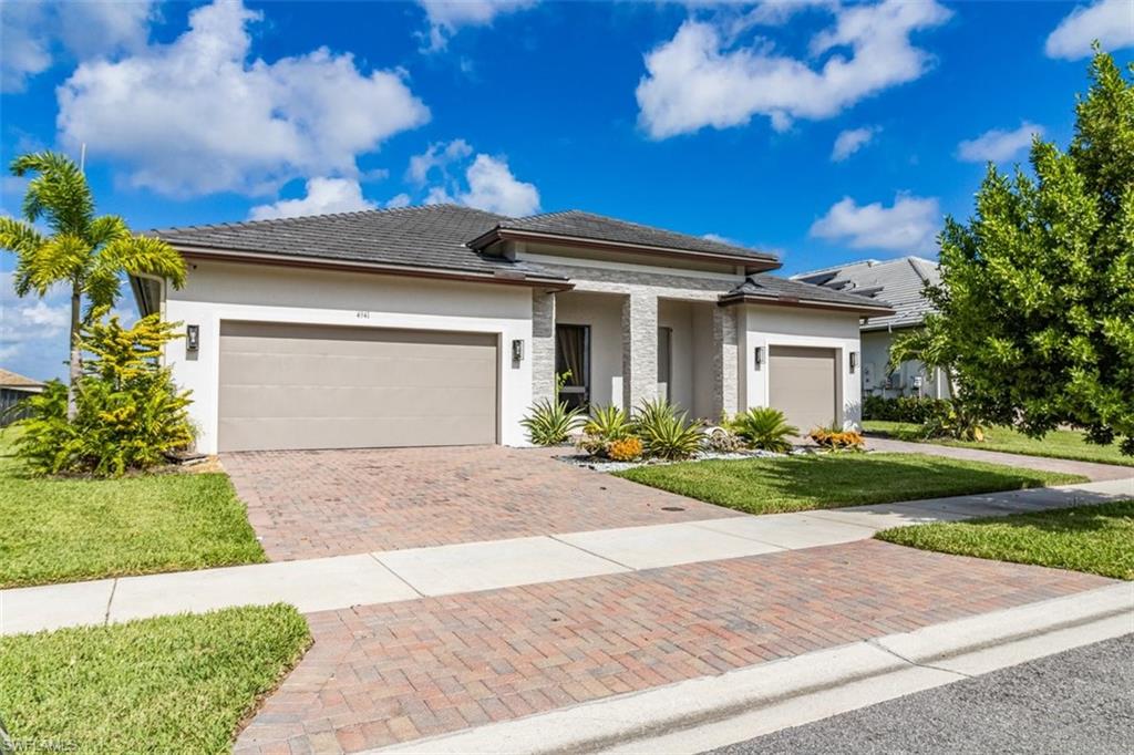 Prairie-style home with a front yard and a garage