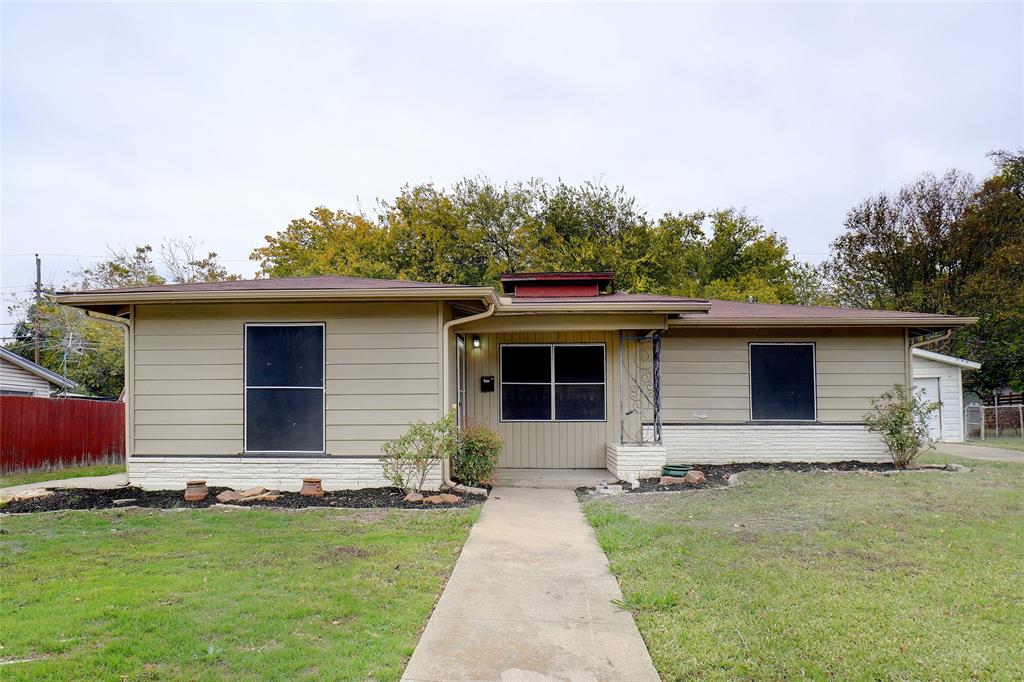 a front view of house with yard and trees in the background