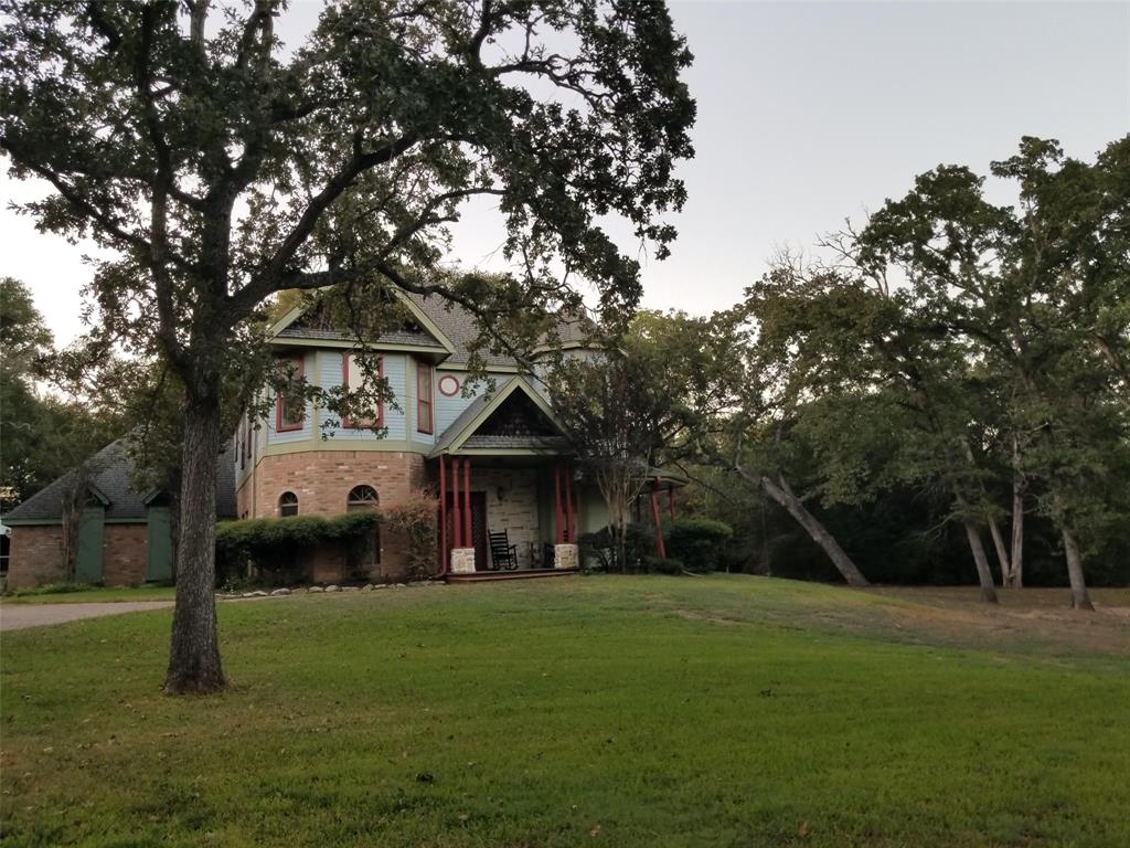 a front view of a house with a yard and trees