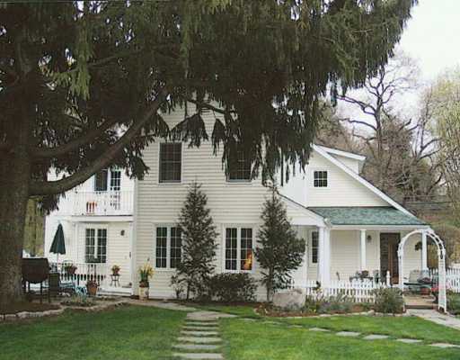 a front view of a house with a garden and trees