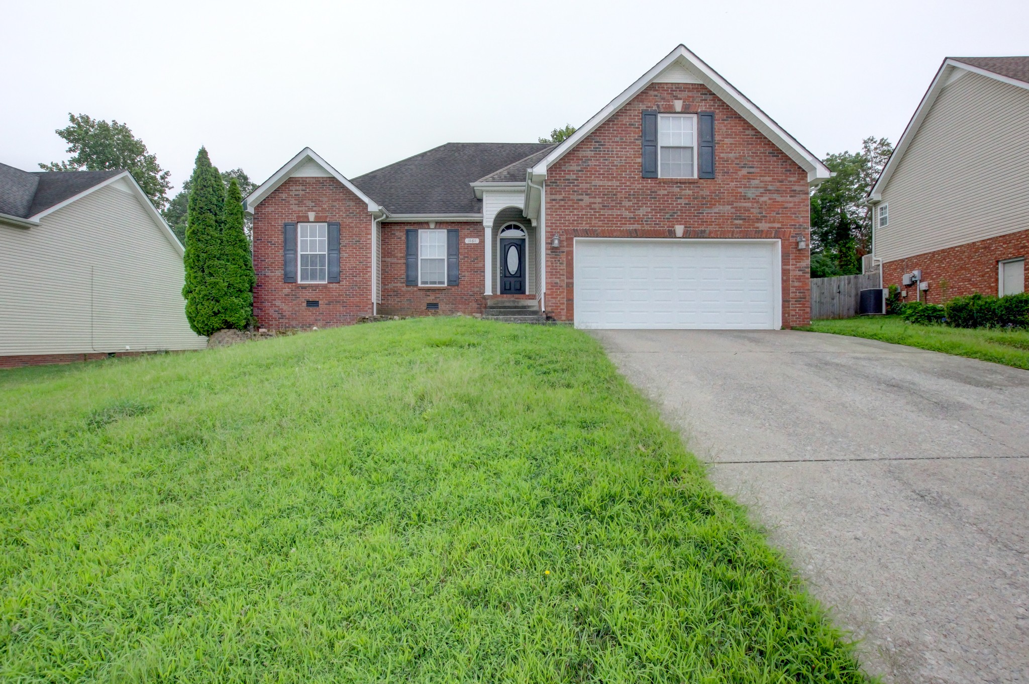 a front view of a house with yard and garage