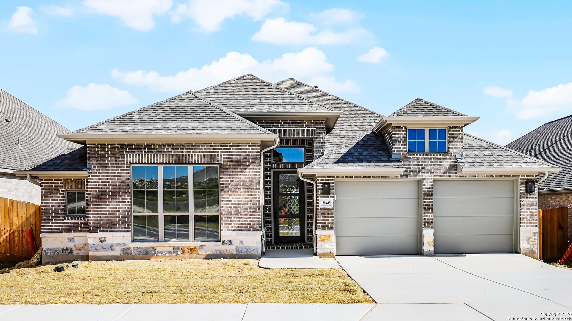 a front view of a house with a yard and garage