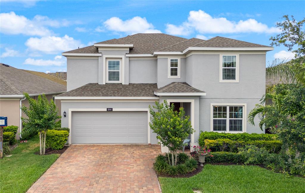 a front view of a house with a yard and garage