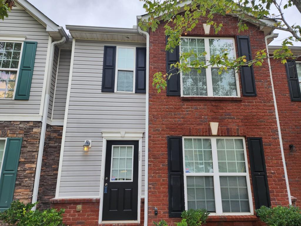 a view of a brick house with a large windows and a large tree