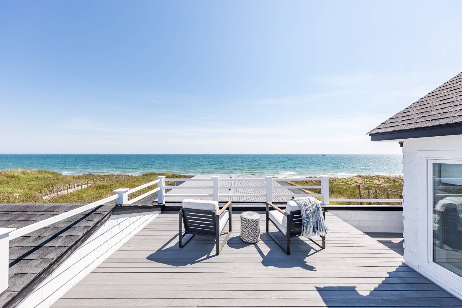 an outdoor space with wooden floor and ocean view