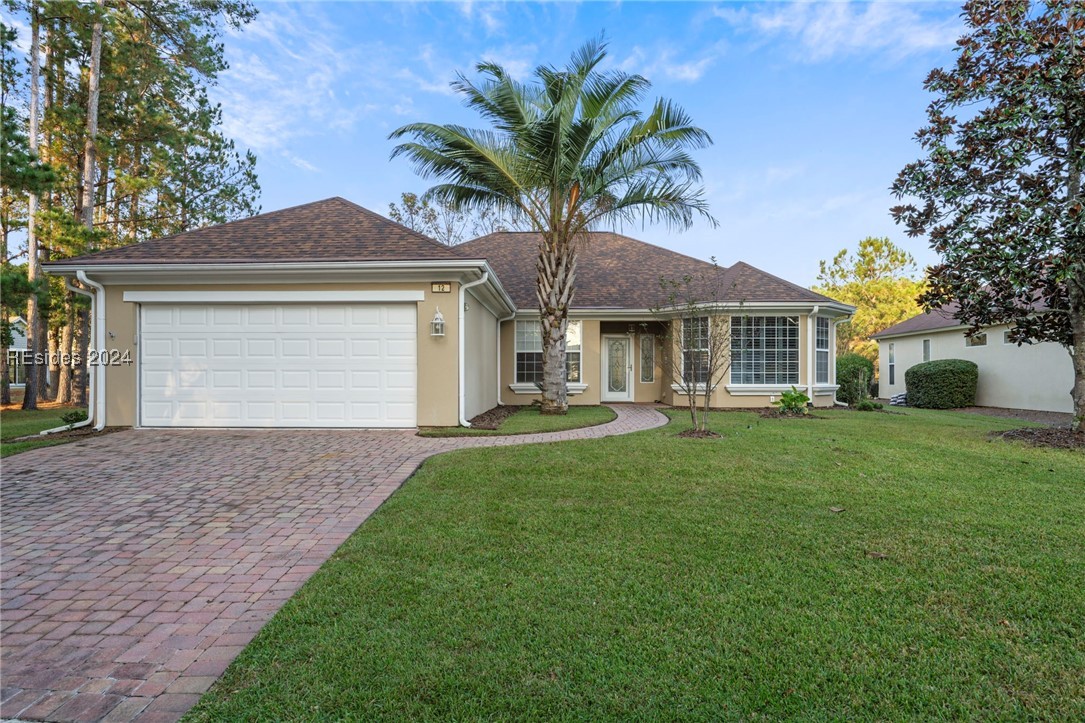 Single story home with a front yard and a garage