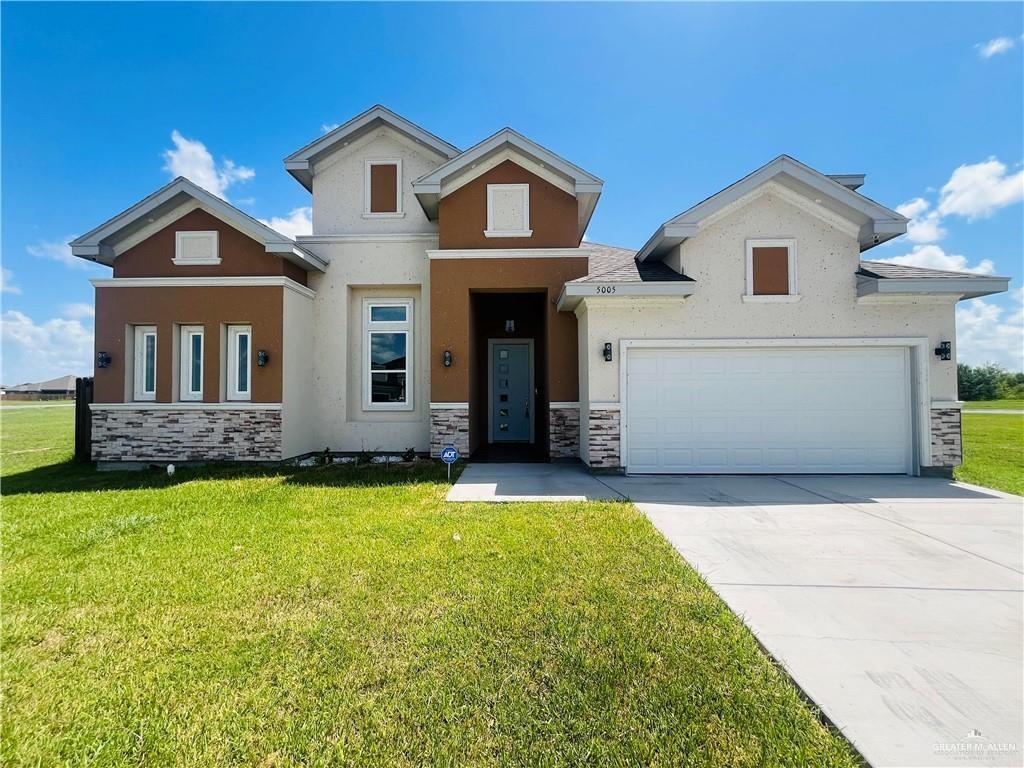 View of front of home with a front lawn and a garage