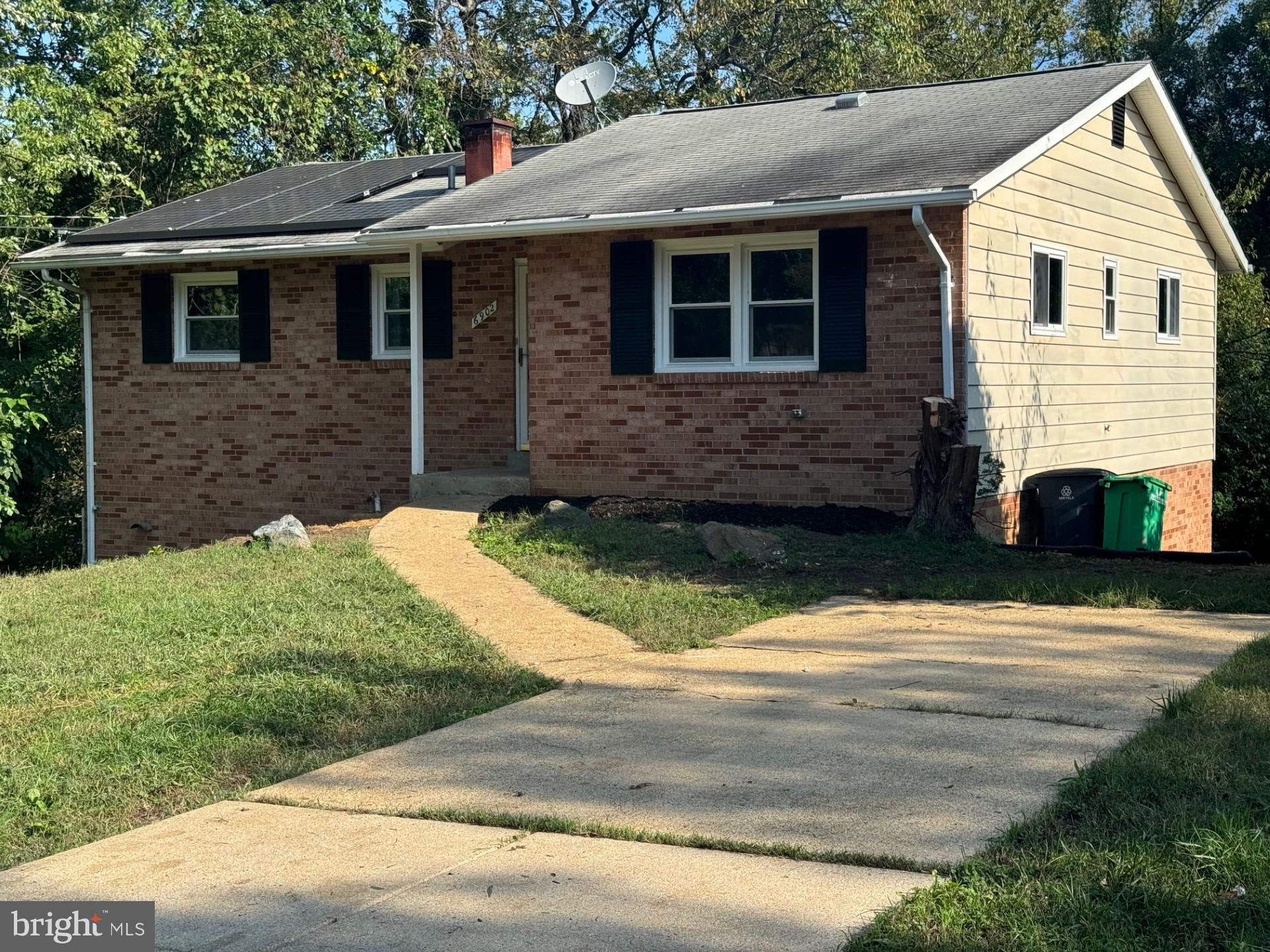 a view of brick house with a yard