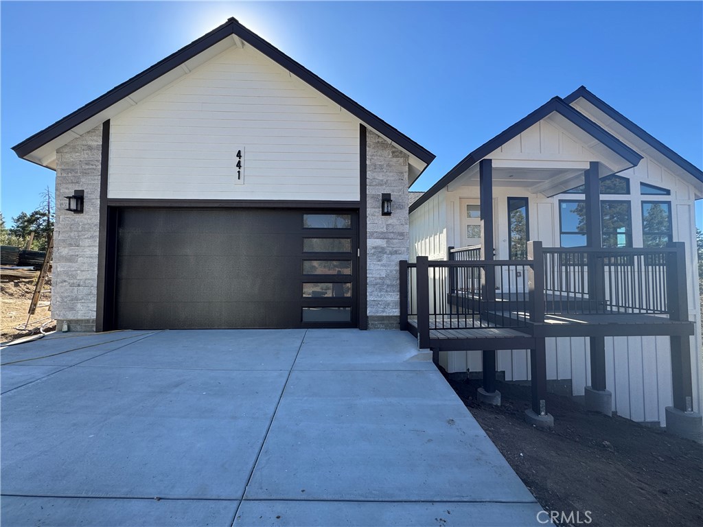 a view of house with wooden deck and a yard