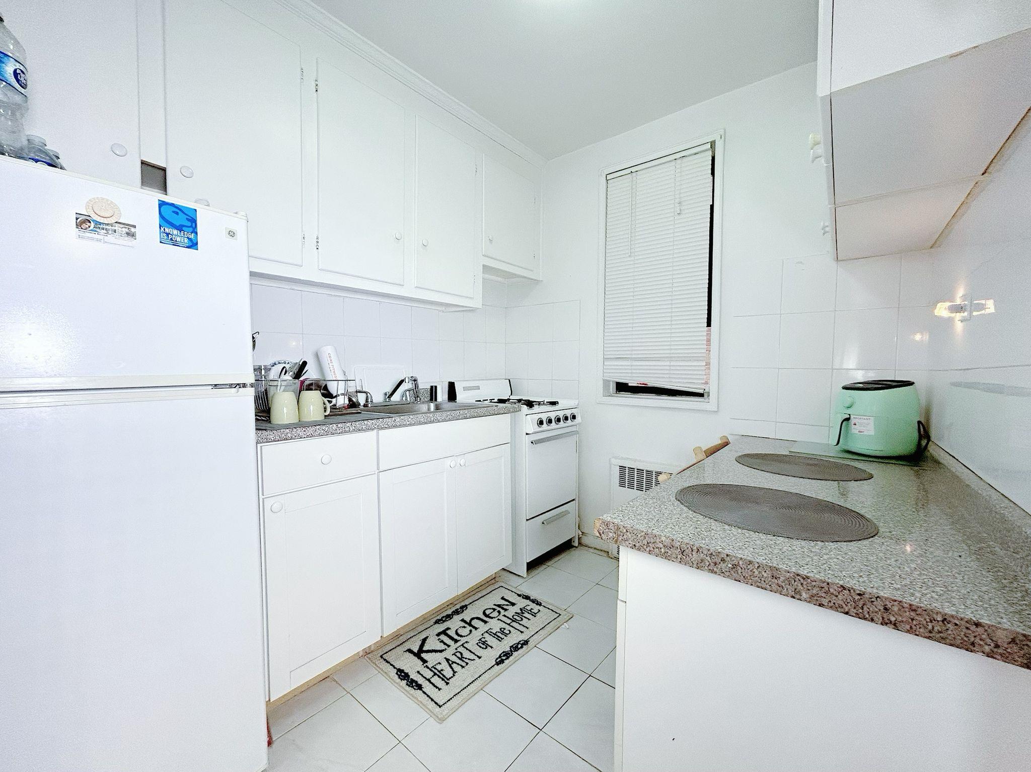 a kitchen with a sink a stove and white cabinets