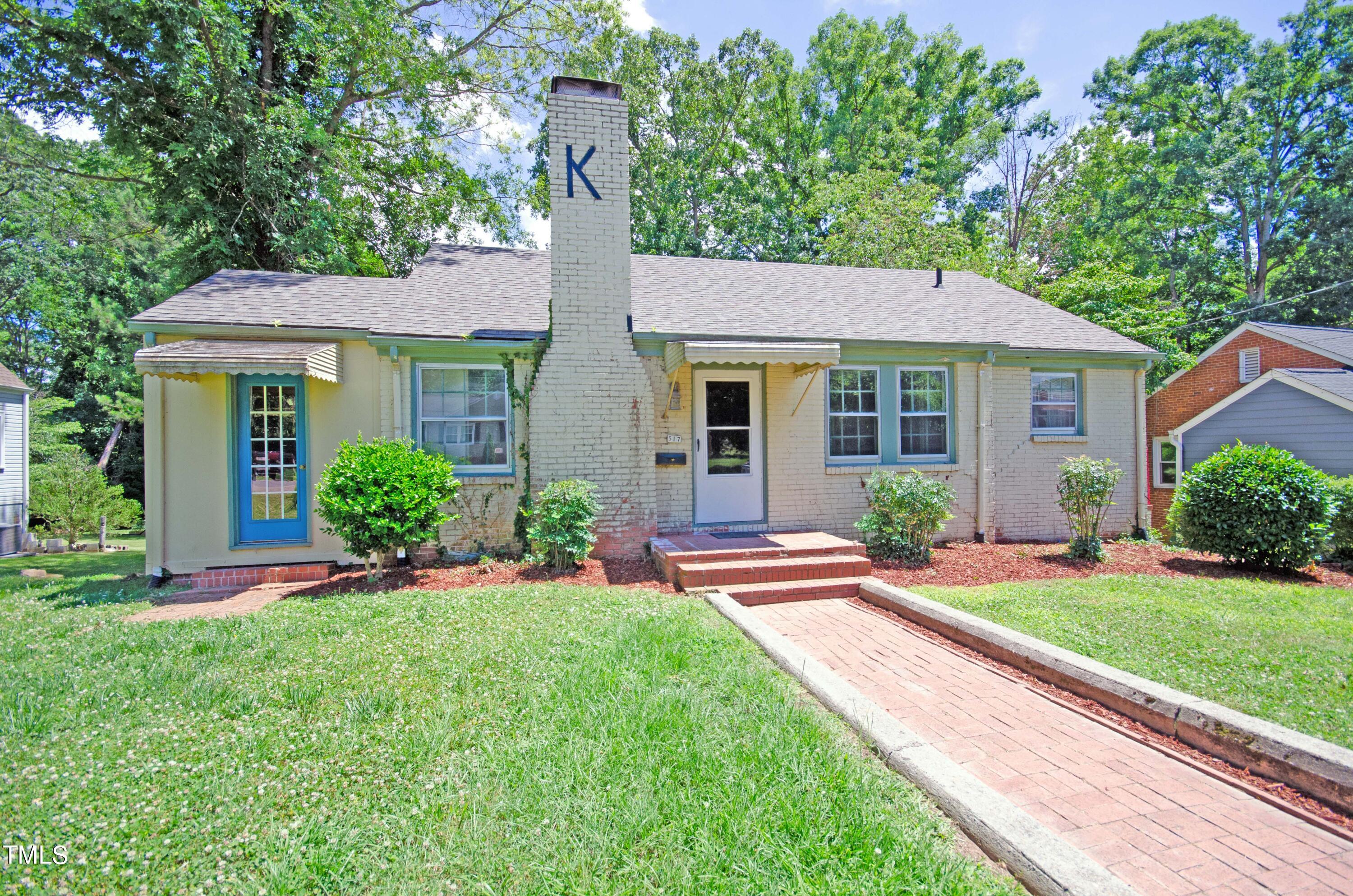 a front view of a house with a yard and potted plants