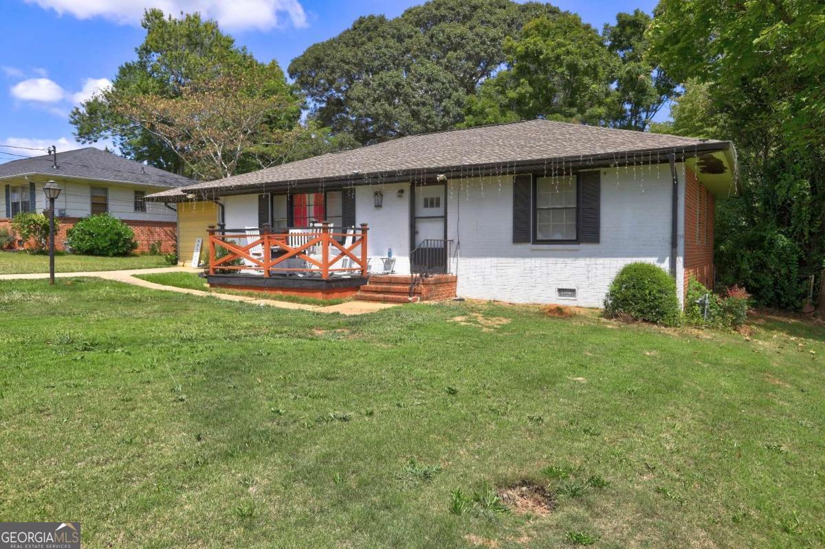 a view of a house with a yard and sitting area