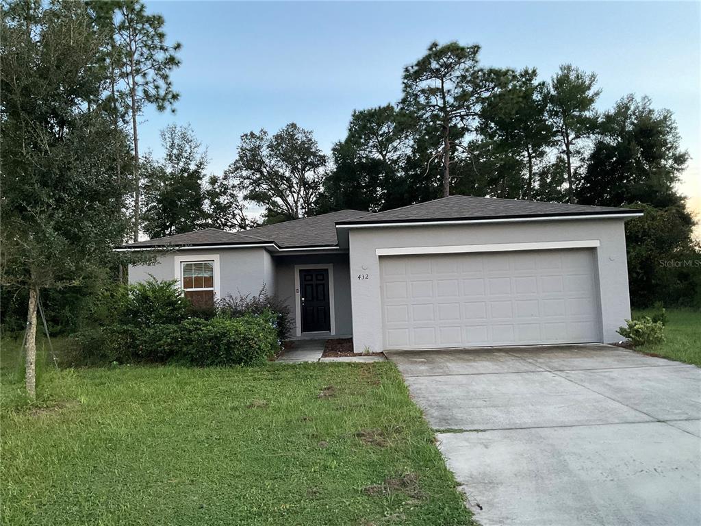 a view of a house with garage and yard