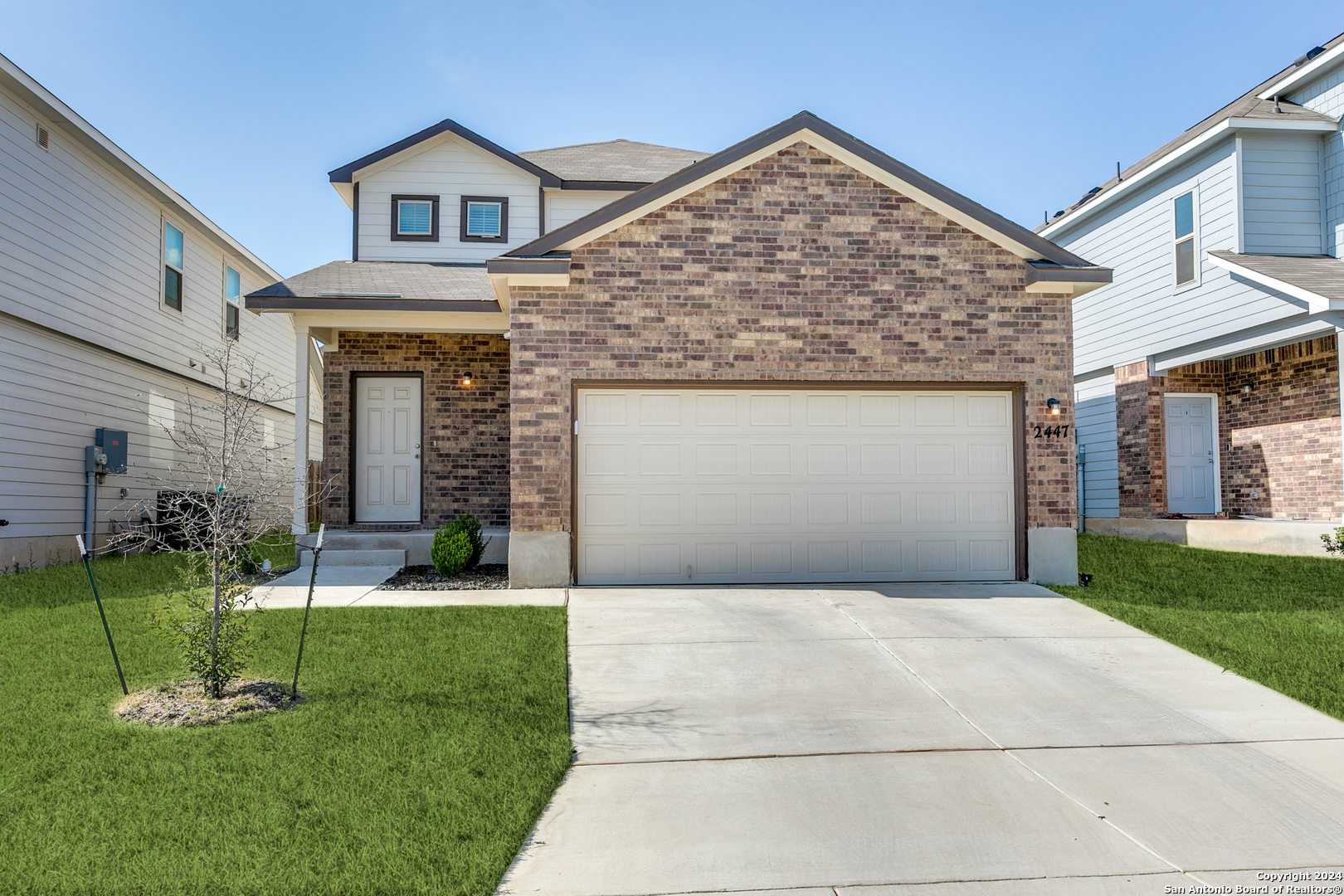 a front view of a house with a yard and garage