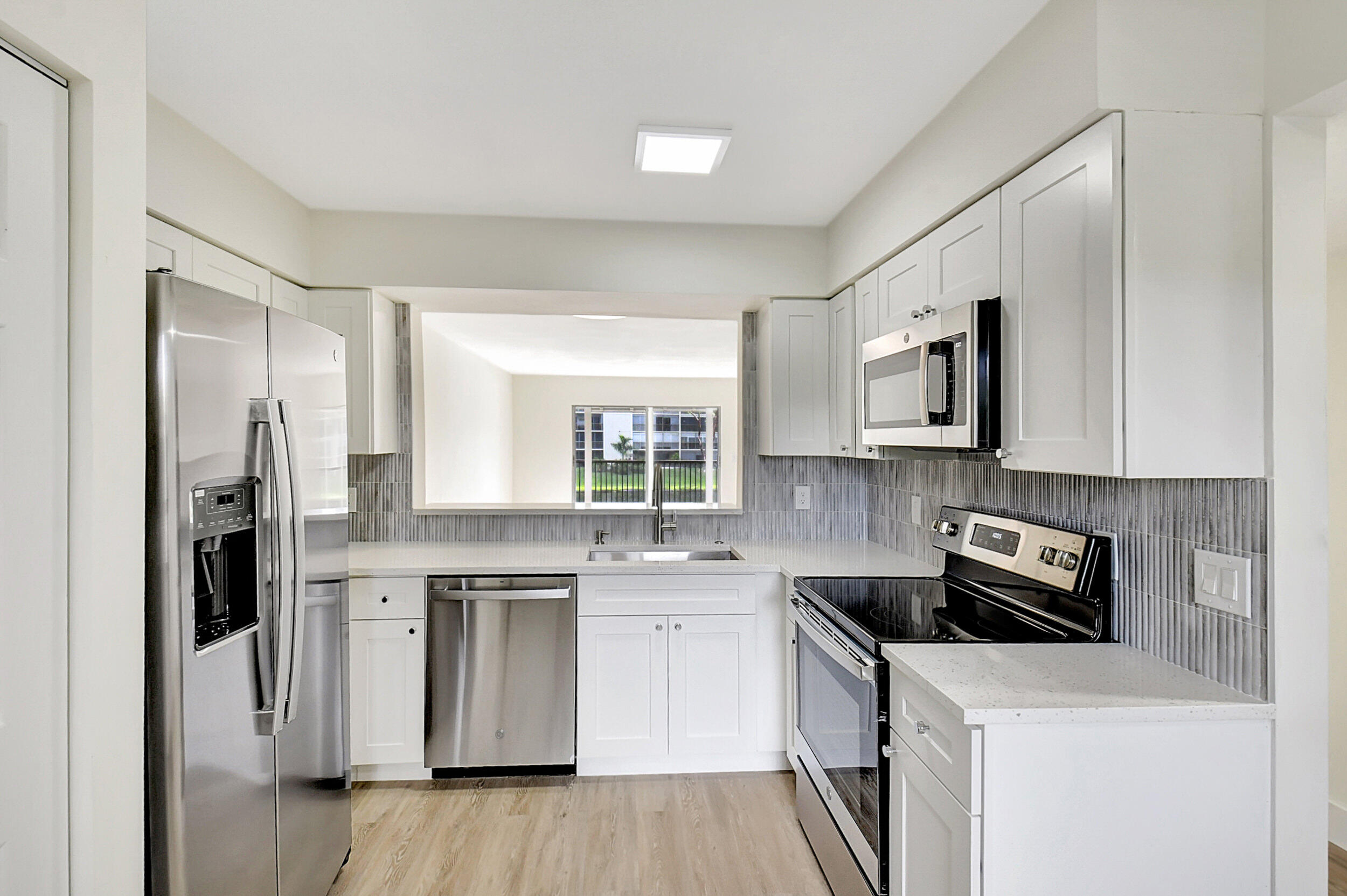 a kitchen with stainless steel appliances a stove microwave and sink