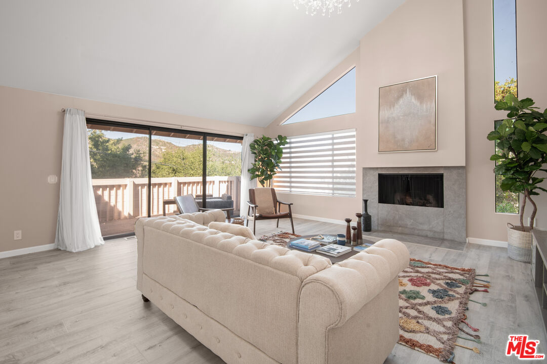 a living room with furniture large windows and a fireplace