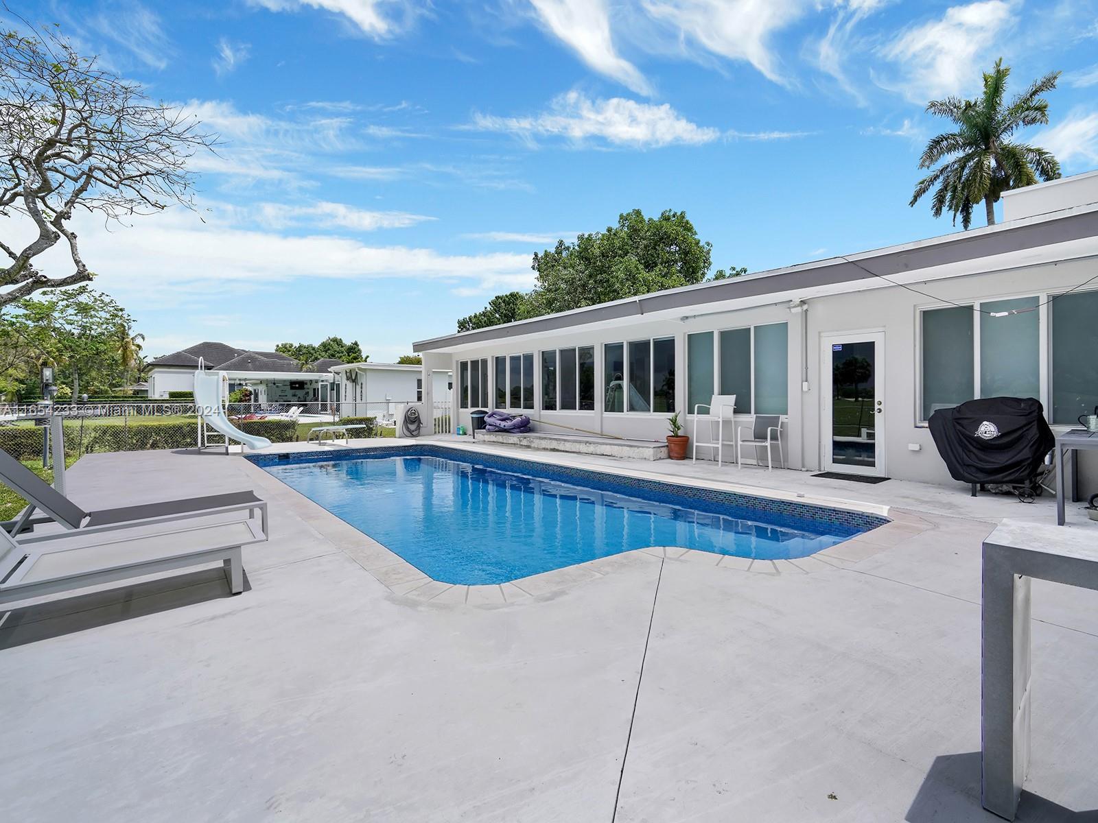 a view of a house with swimming pool and sitting area