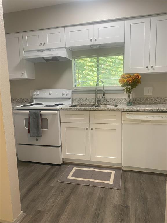 a kitchen with granite countertop white cabinets and white stainless steel appliances