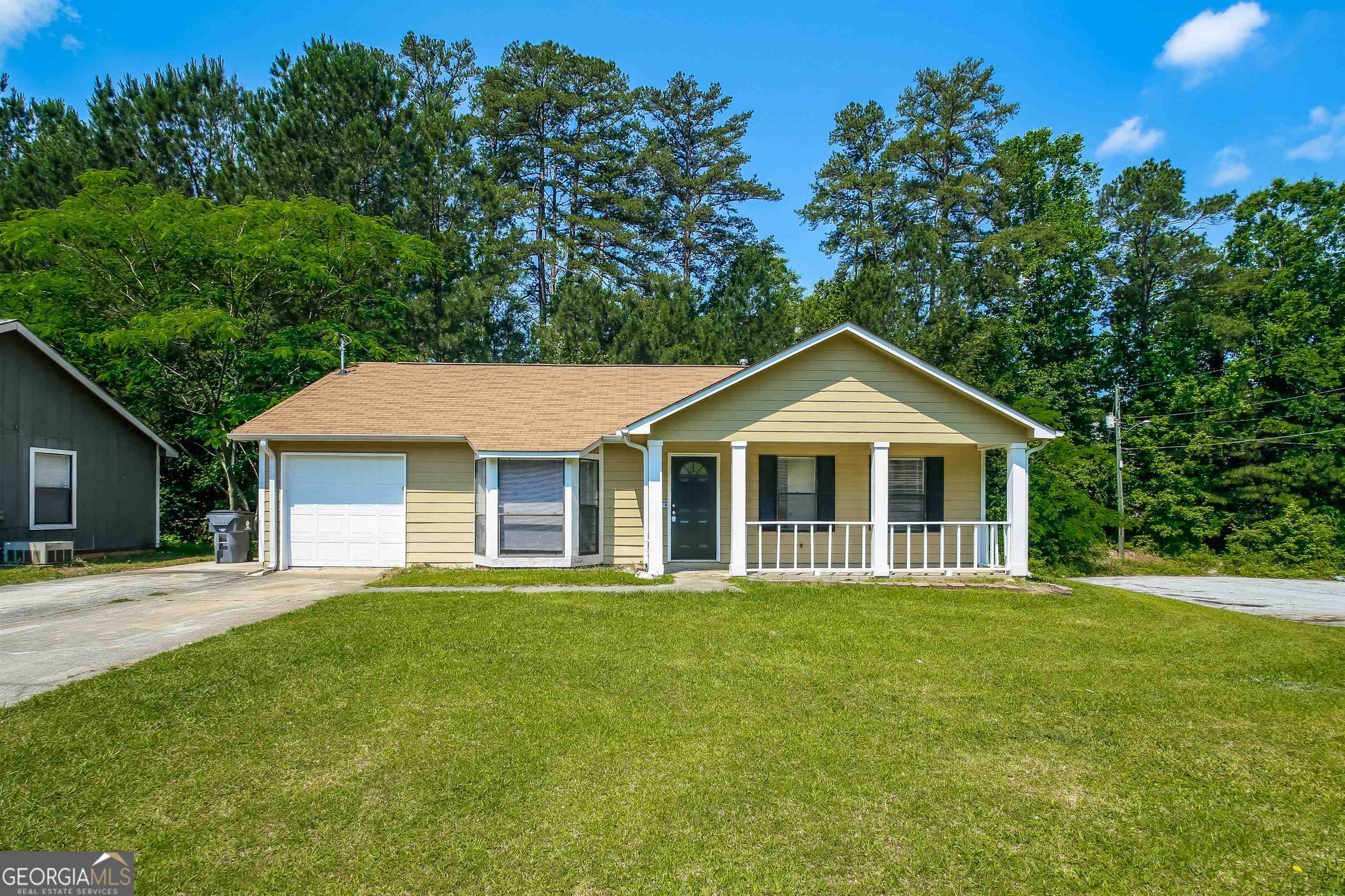 a front view of a house with a yard and trees