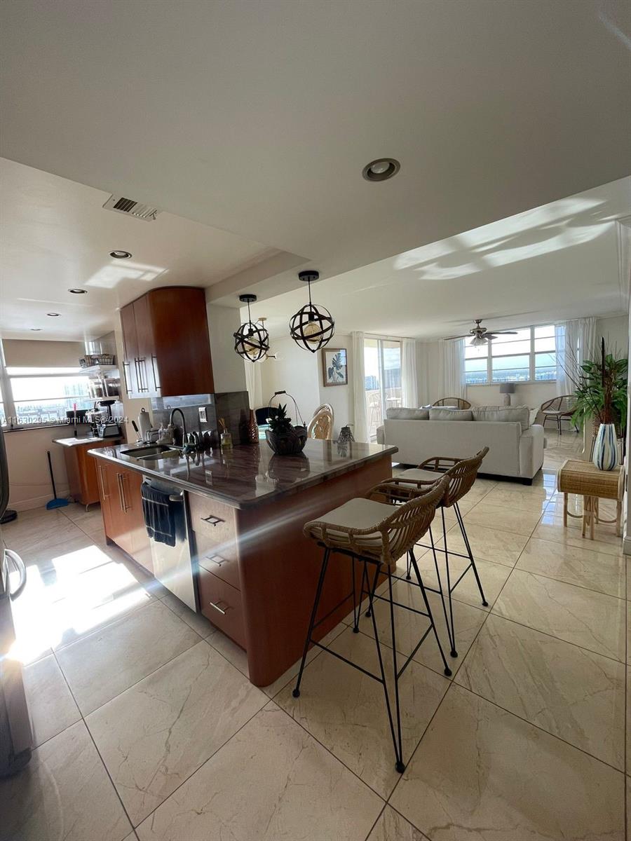 a kitchen with stainless steel appliances kitchen island granite countertop a table and chairs in it