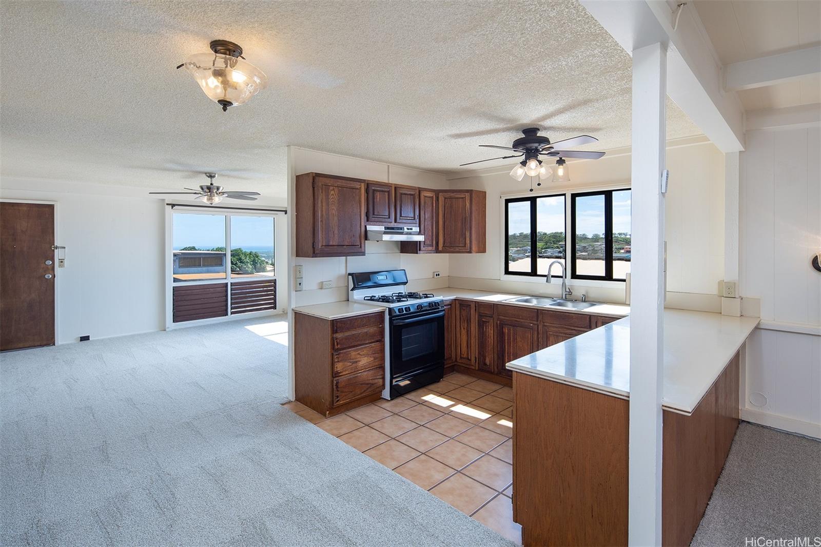 a large kitchen with stainless steel appliances granite countertop a stove refrigerator a sink dishwasher with a dining table and chairs with wooden floor