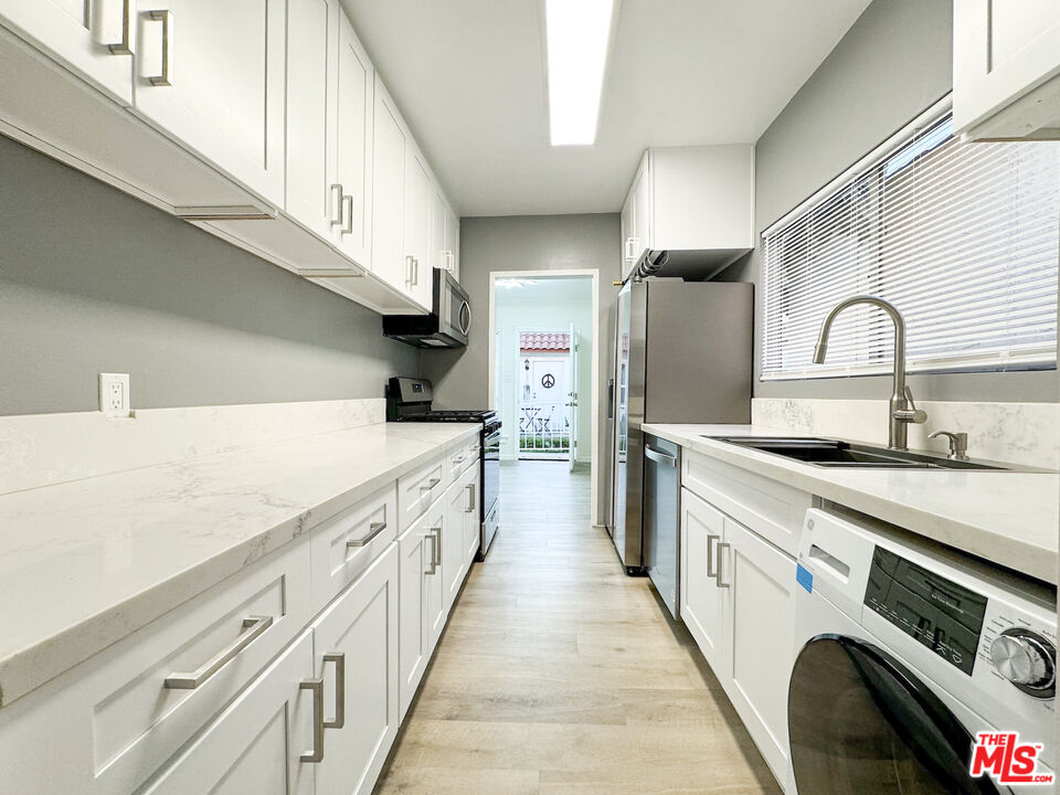 a kitchen with stainless steel appliances a sink and a refrigerator