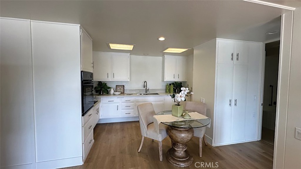 a kitchen with a dining table chairs and white cabinets