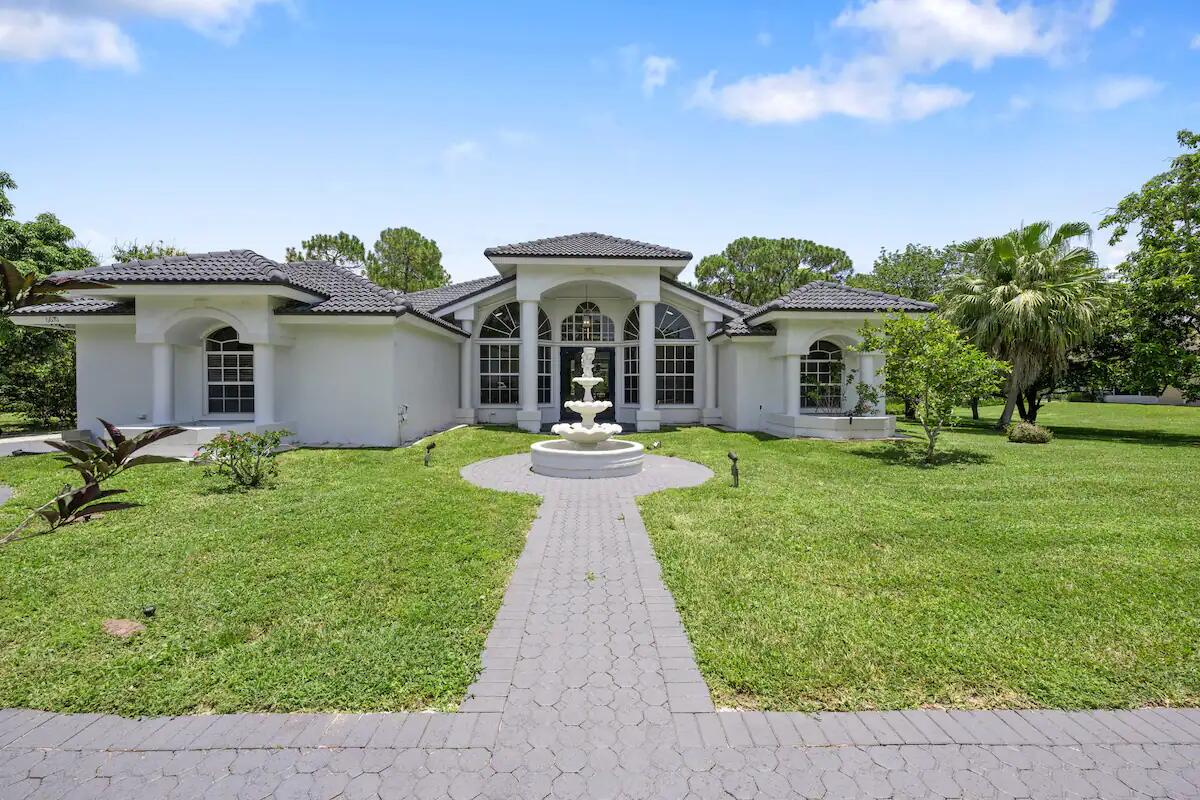 a front view of a house with a garden and yard