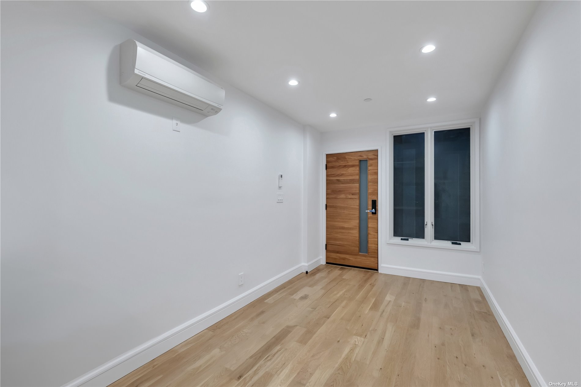 a view of an empty room with wooden floor